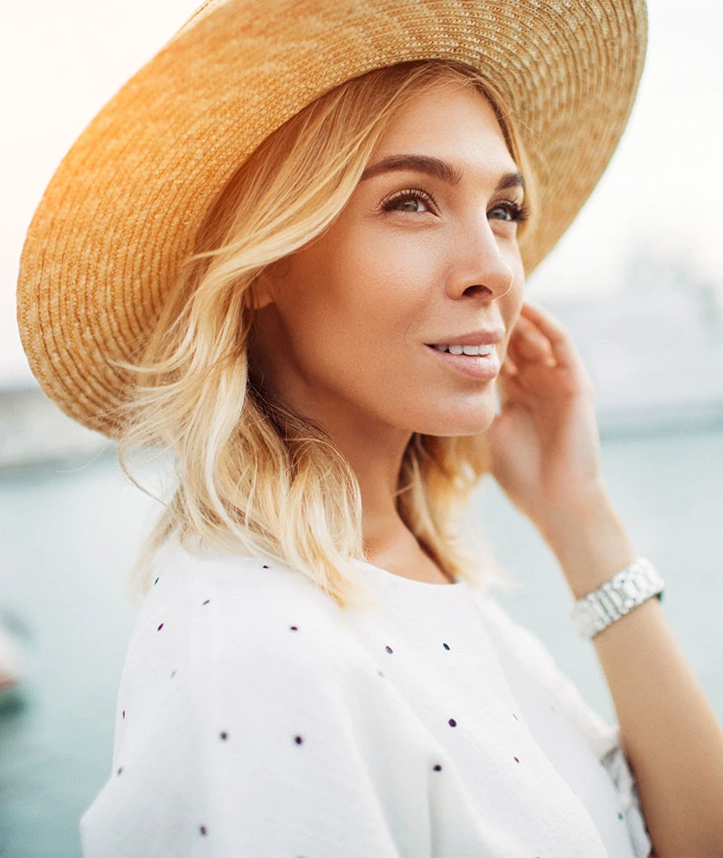 woman smiling in sun hat | Himmarshee Plastic Surgery in Fort Lauderdale