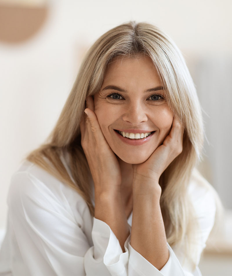 blonde woman smiling with hands on cheeks